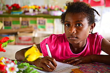 Young girl copying some work from the chalkboard at Kaindi demonstration school in Wewak, Papua New Guinea, Pacific