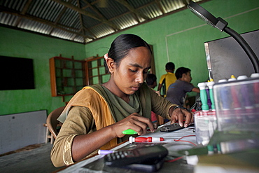 Habiba Akhter, aged 18, a member of a youth club in Afcalpur village, repairing mobile phones, Rangpur District of North West Bangladesh, Asia