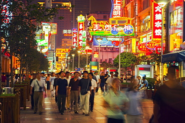 Shoppers in neon lit streets, Shanghai, China, Asia