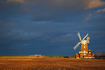 Storm clouds move in over the reedbeds towards Cley Windmill at Cley Next the Sea, Norfolk, England, United Kingdom, Europe