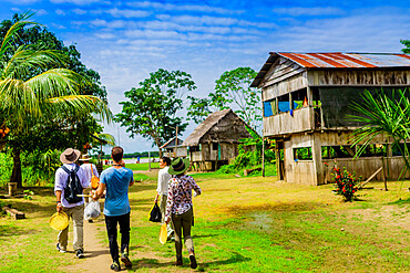 Tourists exploring a village in the Amazon Jungle, Pacaya Samiria National Reserve, Peru, South America