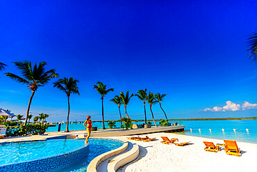 Woman gazing out to the ocean from the pool at Blue Haven Resort, Providenciales, Turks and Caico Islands, Atlantic, Central America