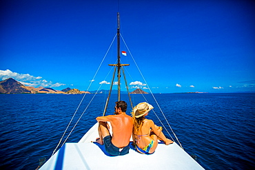 Couple relaxing on a Phinisi boat, Flores Island, Indonesia, Southeast Asia, Asia