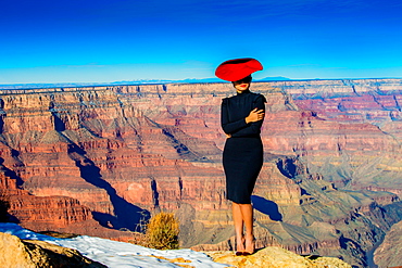 Woman in a red hat posing on the edge of the Grand Canyon, UNESCO World Heritage Site, Arizona, United States of America, North America