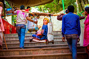 Woman carried in a hanging chair to the temple, Holi Festival, Vrindavan, Uttar Pradesh, India, Asia