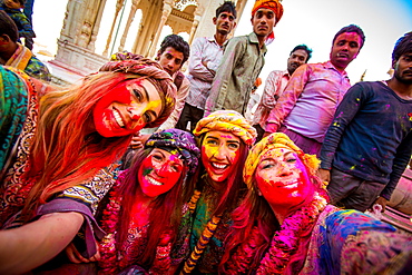 Female tourists stand in front of Temple during the pigment throwing Holi Festival, Vrindavan, Uttar Pradesh, India, Asia