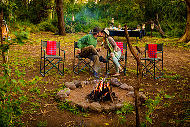 Couple kissing by a safari camp campfire in Zululand, South Africa, Africa