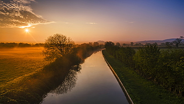 The Shropshire Union canal leads through the Cheshire plain to Beeston Castle and the Peckforton sandstone ridge at sunrise, Cheshire, England, United Kingdom, Europe