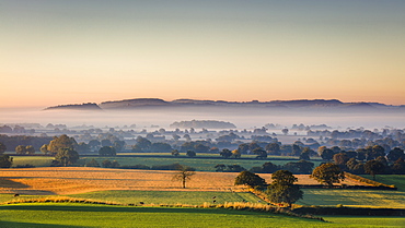 Low autumn morning light rakes across the Cheshire plain with Beeston Castle and the Peckforton sandstone ridge beyond, Cheshire, England, United Kingdom, Europe