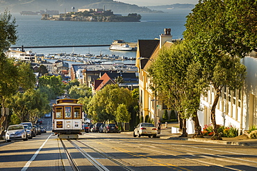 San Francisco city tram climbs up Hyde Street with Alcatraz beyond, San Francisco, California, United States of America, North America