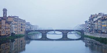 Looking along the Arno River to the Renaissance Ponte Santa Trinita bridge on a misty ethereal morning, Florence, Tuscany, Italy, Europe