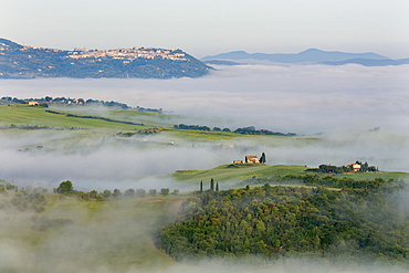 Looking across the Val d'Orcia to Montalcino perched on a hill above cloud and fog lingering in the valley below, UNESCO World Heritage Site, Tuscany, Italy, Europe