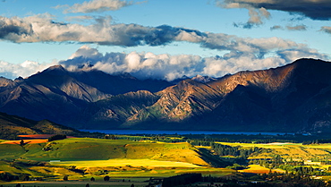 The plains and lakes of Otago region framed by cloud capped mountains, Otago, South Island, New Zealand, Pacific