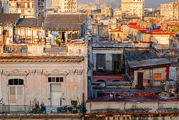 A man comes out of his rooftop home in the early morning light in Havana, Cuba, West Indies, Caribbean, Central America