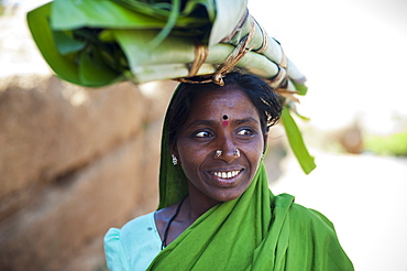 A woman carries a roll of banana leaves which will be used to wrap food, Karnataka, India, Asia