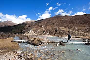 Trekking across a temporary bridge between Shomuthang and Robluthang on the Laya-Gasa trekking route, Gasa District, Bhutan, Asia