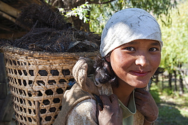 A Bhutanese girl carries fodder to feed her livestock in a village near Paro, Bhutan, Asia