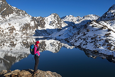 A woman looks out over the holy lake of Gosainkund in the Langtang region, Himalayas, Nepal, Asia