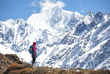 A woman trekking in the Langtang Valley with a view of Ganchempo in the distance, Langtang Region, Himalayas, Nepal, Asia