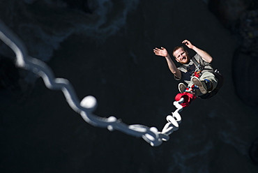 A man smiles for the camera as he is bounced back up during a Bungee jump at The Last Resort, Nepal, Asia