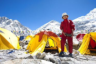 A woman stands by her tent shortly after climbing Everest, Khumbu Region, Himalayas, Nepal, Asia