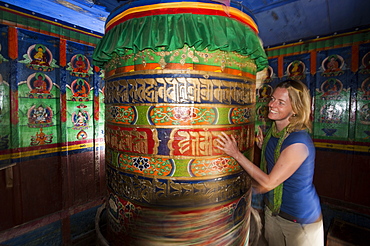 A trekker spins a Buddhist prayer wheel while trekking towards to Everest Base Camp, Khumbu Region, Nepal, Asia