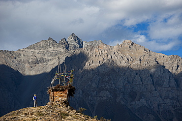 A small chorten strewn with prayer flags marks the top of a hill near Ringmo in the remote Dolpa region, Himalayas, Nepal, Asia