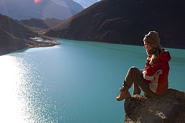 A trekker in the Everest region stops half way up Goyko Ri to enjoy the views, Khumbu Region, Nepal, Asia