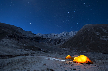 In the little explored Juphal valley in the remote Dolpa region, a man stands outside his tent on a cold night, Dolpa, Himalayas, Nepal, Asia