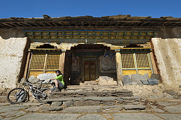 A mountain biker takes a well earned rest at Mu Gompa, the last village in the Tsum Valley, Nepal, Asia