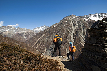 Trekkers stop by a chorten in the Tsum Valley near Mu Gompa, Nepal, Asia