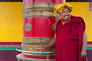 A Buddhist monk (lama) spins a prayer wheel at Diskit Monastery in the Nubra Valley, Ladakh, India, Asia