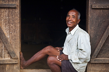 An old farmer sits in the doorway of his house, Meghalaya, India, Asia