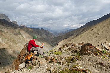 Stopping to savour the views from the top of the Konze La, at 4900m, during the Hidden Valleys trek in Ladakh, a remote Himalayan region, India, Asia