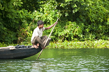 A boy paddles across Kaptai Lake, Chittagong Hill Tracts, Bangladesh, Asia