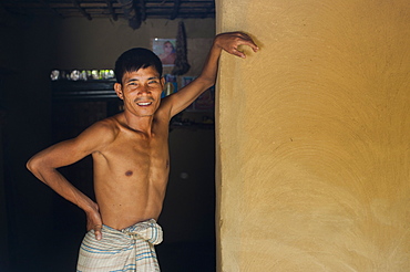 A man stands in the entrance of his mud walled house near Kaptai Lake, Chittagong Hill Tracts, Bangladesh, Asia