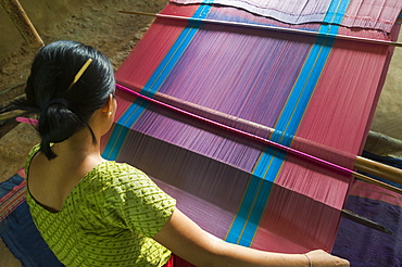 A woman weaves traditional clothes using a hand loom, Chittagong Hill Tracts, Bangladesh, Asia