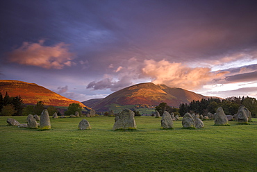 Castlerigg Stone Circle in autumn at sunrise with Blencathra bathed in dramatic dawn light, Lake District National Park, Cumbria, England, United Kingdom, Europe