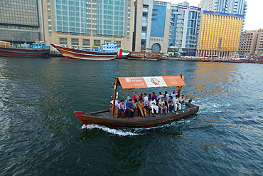 A water taxi carries passengers across Dubai Creek, Dubai, United Arab Emirates, Middle East