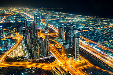 The street lights and skyscrapers of Dubai are seen at night from high above the city, Dubai, United Arab Emirates, Middle East