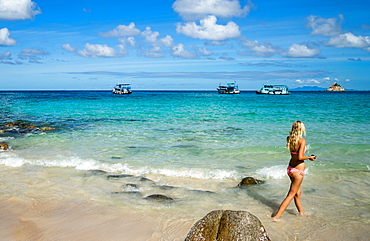 A woman in a bikini walks along a beach on Koh Tao, Thailand, Southeast Asia, Asia