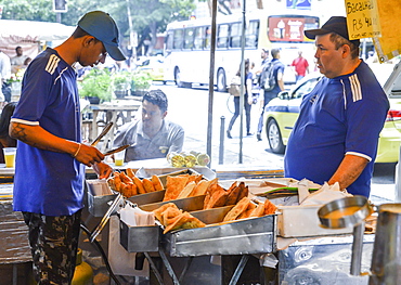 Market workers prepare a fried dish, known as pastel which can be served with cheese or meat, Rio de Janeiro, Brazil, South America