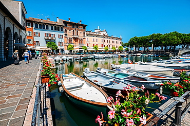 Boats on marina with tourists at cafes and restaurants at Desenzano del Garda, Lake Garda, Lombardy, Italian Lakes, Italy, Europe