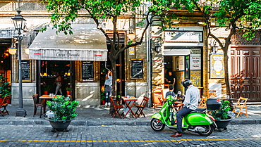 Man on green Vespa on Calle Mateos Gago in the historic centre of Seville, Andalusia, Spain, Europe