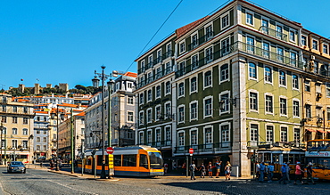 Traditional trams at Praca da Figueira with Castelo Sao Jorge on the far left, Lisbon, Portugal, Europe