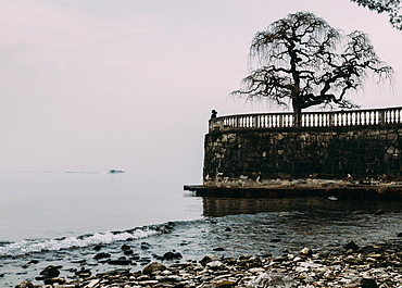 Unidentified woman looking at Lake Maggiore on a cold winter's day, Piedmont, Italian Lakes, Italy, Europe