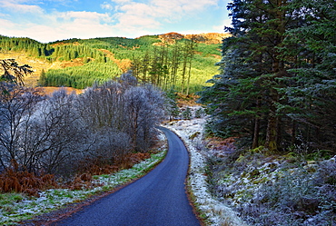 A winter view of a winding road through a wooded valley in the Ardnamurchan Peninsula, the Scottish Highlands, Scotland, United Kingdom, Europe