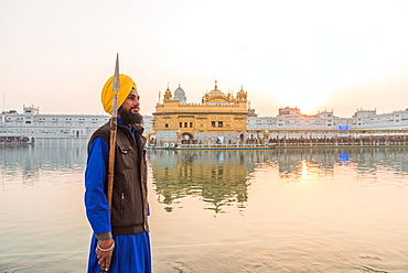 Guard standing by tank, the Golden Temple, Amritsar, Punjab, India, Asia