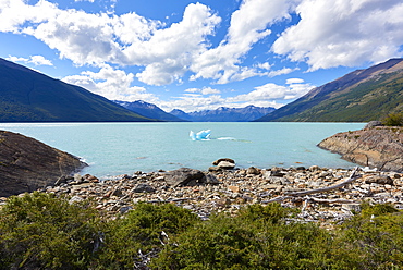 A single iceberg floating near the shore in Lago Argentino near Perito Moreno Glacier, with mountains in the background, Los Glaciares National Park, UNESCO World Heritage Site, Patagonia, Argentina, South America