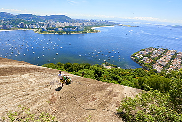 Abseilers in Morro da Urca in Rio de Janeiro with panoramic view in the background, Rio de Janeiro, Brazil, South America